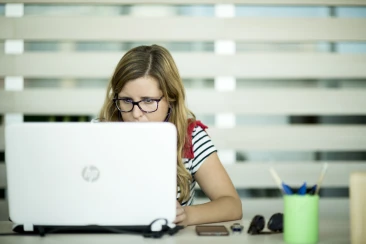 Una coworker mirant el seu ordinador desde el seu lloc de treball